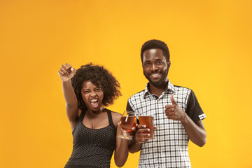 The afro couple or happy young people laughing and drinking beer at studio