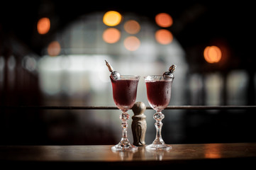 Two elegant glasses filled with fresh sweet and strong summer Arnaud cocktail on the blurred background