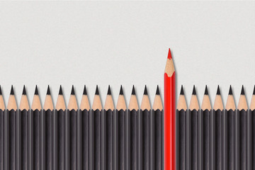 Red pencil among a group of black pencils. Concept of outstanding mind among the gray mass