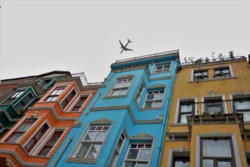 Obraz premium A plane is flying low over Balat houses