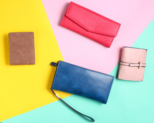 Many leather purses on a colored pastel background. Top View.