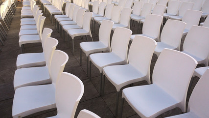 Many white chairs. Rows of plastic white chairs - seats for spectators or fans.