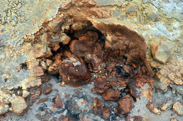 Multicolored smooth stones around the smoking fumarole