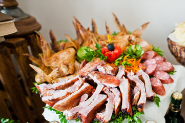 Close-up photo of sour and salty snacks on the wedding banquet along with bottles of beer.