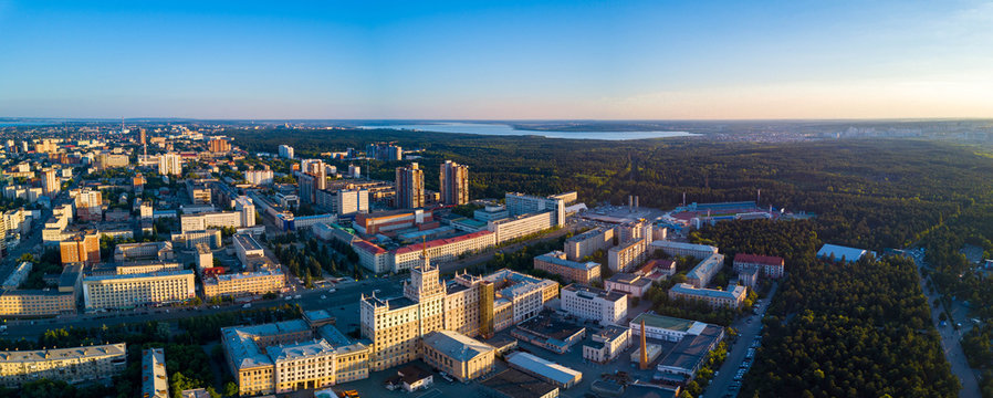 Aerial drone panoramic view of university campus in the city center of Chelyabinsk, huge city park with coniferous forest, recreation zone in polluted city, sunny evening in South Ural capital, Russia