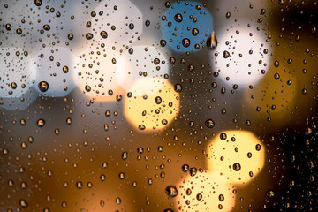 Drops of rain on window with abstract lights