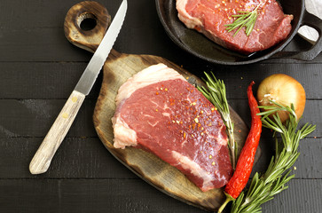 Raw meat. Raw beef steak on cutting Board and spices.