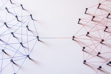 Connecting networks concept - two network connected with yarn red and blue on white paper....