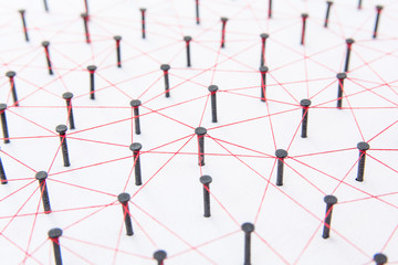 Connecting networks concept - network connected with yarn red on white paper with copy space....