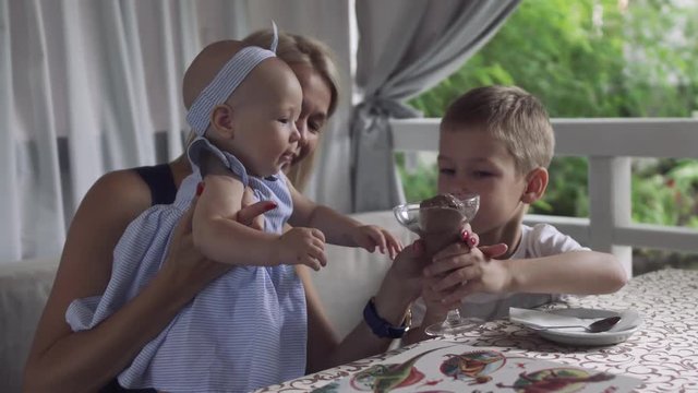 Baby girl tries to grab glass with ice cream