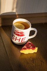 Cheesecake with raspberries and black tea with lemon close-up. Light breakfast.