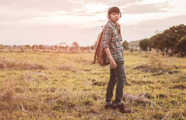 Teens are listening to music at close range with a light sunset background.