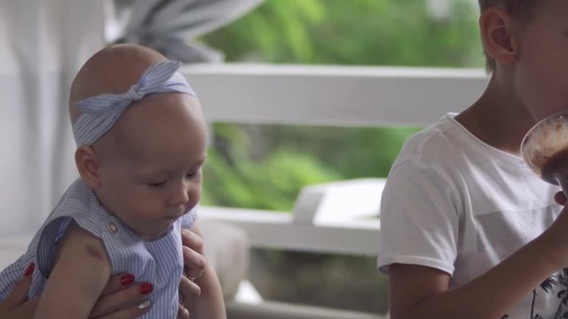 Little boy has fun with his little sister and eat ice cream in cafe