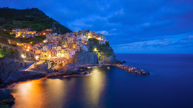 Beautiful colorful panoramic photo of village Manarola by night in Cinque Terre, Italy.