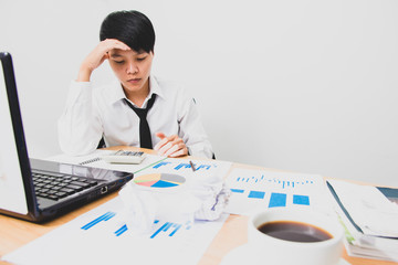 Asian business young man in white suit are stress worry probleme working sitting on chair in office.