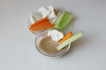 Asian nut sauce with vegetables on white table
