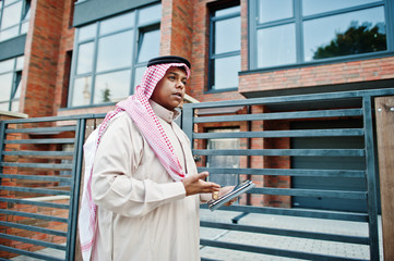 Fototapeta premium Middle Eastern arab man posed on street against modern building with tablet at hands.