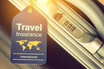 Travel safety and travel insurance concept : Travel insurance tag is hung near a numeric combination lock. Travel insurance is intended to cover lost luggage, trip cancellation, accident, losses, etc
