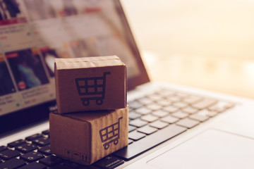 Shopping online concept - Shopping service on The online web. with payment by credit card and offers home delivery. parcel or Paper cartons with a shopping cart logo on a laptop keyboard