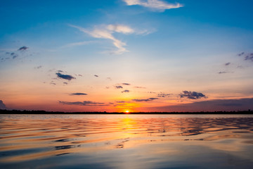 Sunset in the lake. beautiful sunset behind the clouds above the over lake landscape background. dramatic sky with cloud at sunset