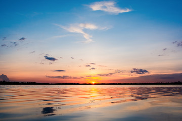 Sunset in the lake. beautiful sunset behind the clouds above the over lake landscape background. dramatic sky with cloud at sunset