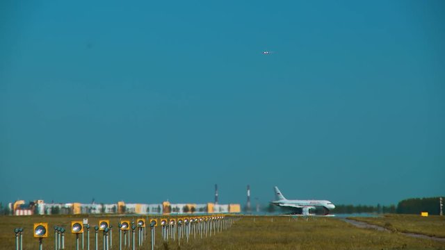 The taxiing of the aircraft on the strip after landing and the next board, preparing for landing. View through the hot air from the ground