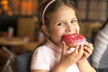 happy girl eating pastry at a cafe. Harmful sweet food. Trends in food. Copy space.