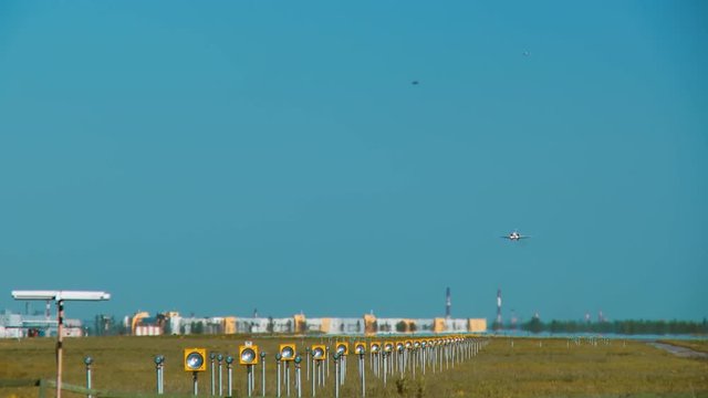 Runway with two aircraft preparing to land. View through the hot air from the ground
