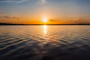 Sunset in the lake. beautiful sunset behind the clouds above the over lake landscape background. dramatic sky with cloud at sunset