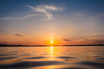 Fototapeta premium Sunset in the lake. beautiful sunset behind the clouds above the over lake landscape background. dramatic sky with cloud at sunset