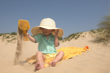 Two year old boy playing on the beach 