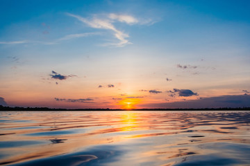 Sunset in the lake. beautiful sunset behind the clouds above the over lake landscape background. dramatic sky with cloud at sunset