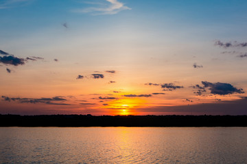 Sunset in the lake. beautiful sunset behind the clouds above the over lake landscape background. dramatic sky with cloud at sunset