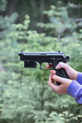 Woman shoots from air gun in forest