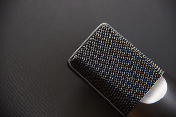 Musical equipment, Professional condenser studio microphone, dark color. Close up from above