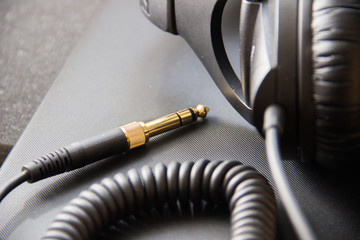 Musical equipment, Professional studio black headphones and jack cord. Close up from above