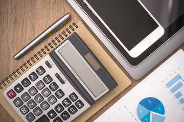 business documents on office table with smart phone and digital tablet and graph financial with social network diagram and computer laptop on wood desk