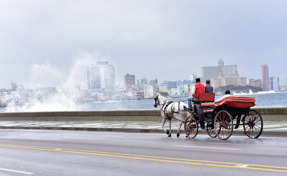 Tourists In A Horse And Carriage Ride Along El Malecon, Havana, Cuba