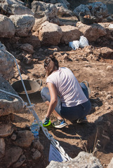Girl archaeologist at work on the site of prehistoric onuments of Menorca