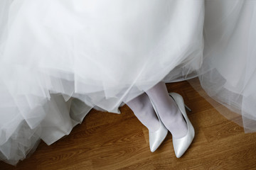 Fototapeta na wymiar Morning preparations. Gorgeous bride in white luxury dress is getting ready for wedding.