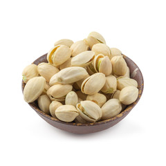 Pistachios nuts in wooden bowl isolated on a white background