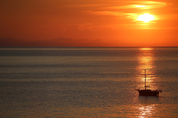 Ship in the sea on the sunrise near the coast