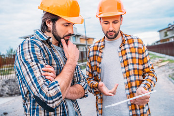 confident architects using digital tablet at construction site