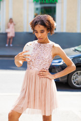 Young beautiful girl is photographing herself on a mobile phone