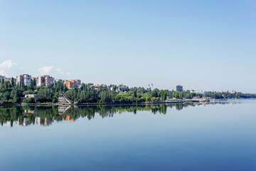 Fototapeta premium view to river and blue sky over it and city on horizon