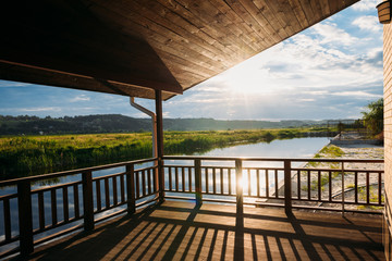 view of beautiful sunset over river from wooden terrace