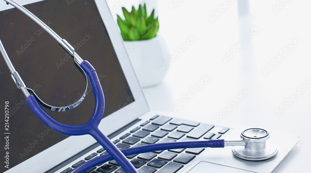 Wall mural stethoscope lying on a laptop keyboard in a concept of online m