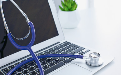 Stethoscope lying on a laptop keyboard in a concept of online m