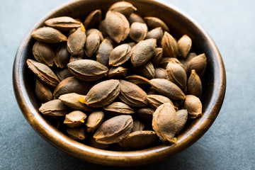 Dried Apricot Kernels in Wooden Bowl.