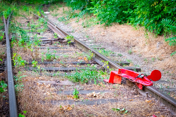 railroad tracks with a bright red traffic lock from the passage, prohibiting the background